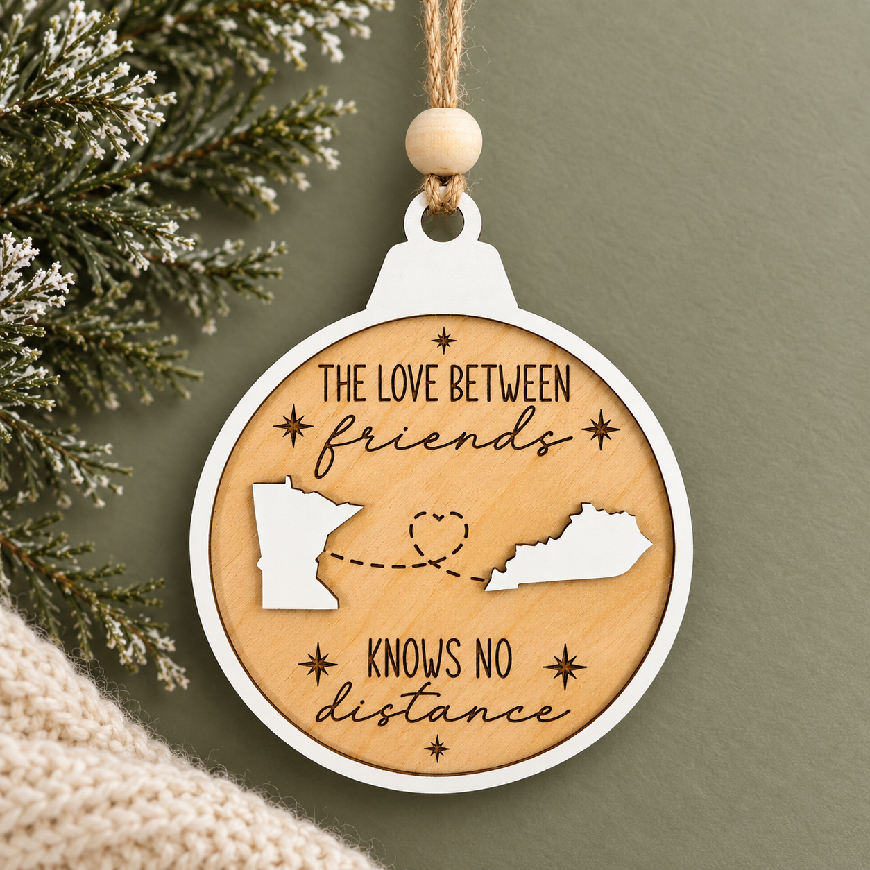 Personalized long distance wood Christmas ornament featuring two custom U.S. states connected by a heart with customizable relationship wording.