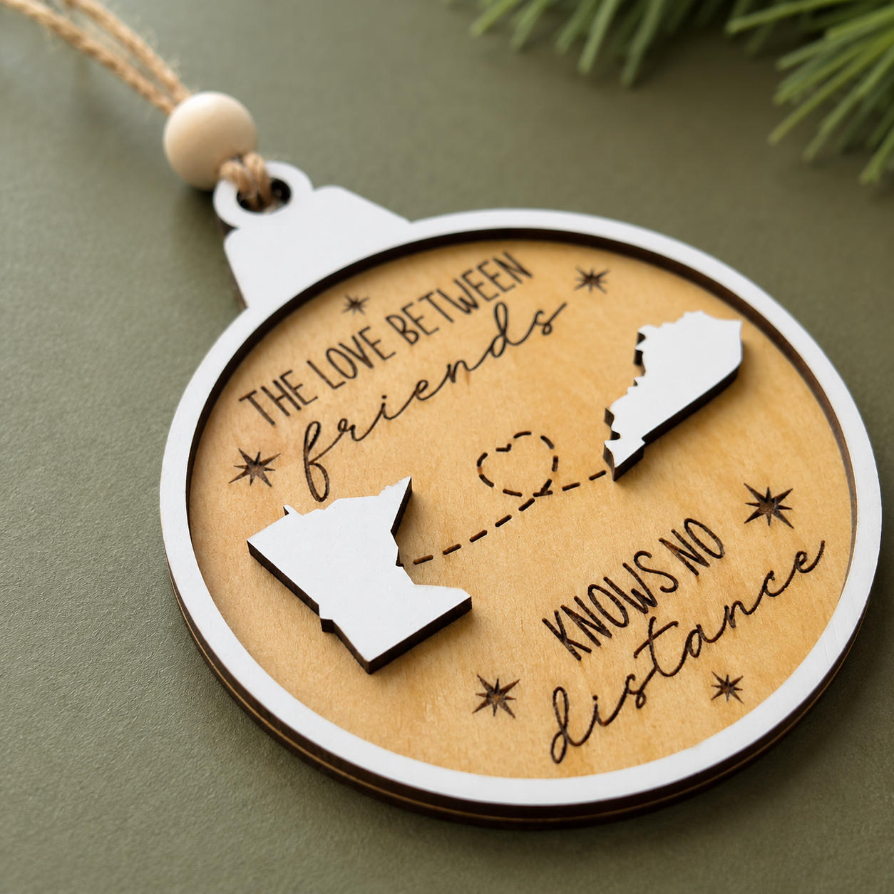 Angled view of a personalized layered wood ornament highlighting raised custom state pieces, engraved details, and handcrafted construction.