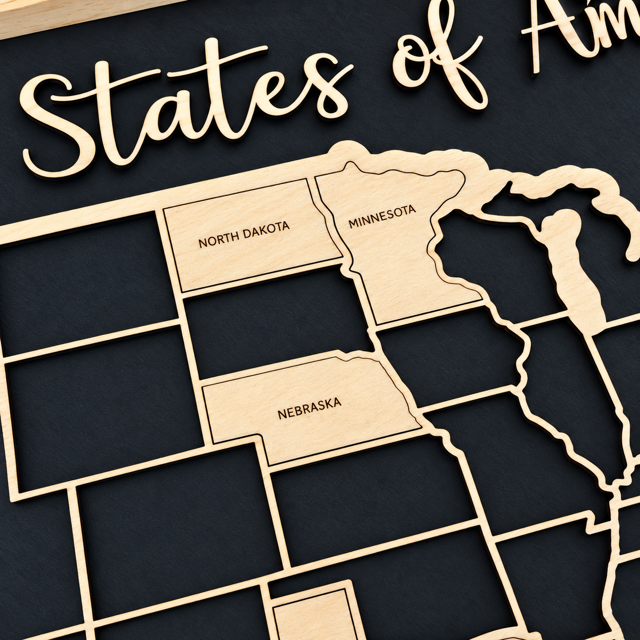 Close-up of USA travel map with labeled wooden state pieces added to track states visited