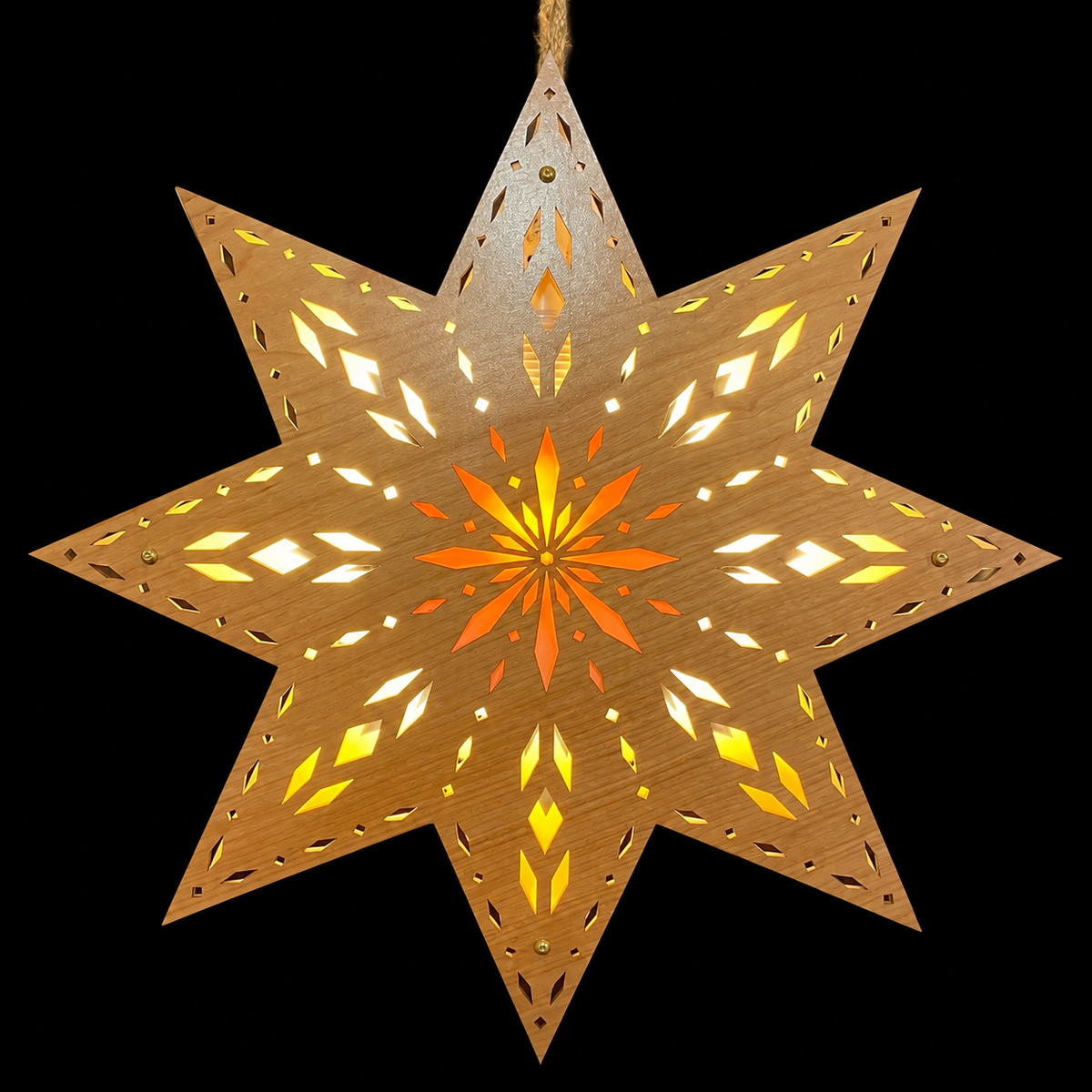 Illuminated 12-inch Scandinavian wooden Welcome Light with geometric laser-cut details and glowing orange starburst center against a solid black background.