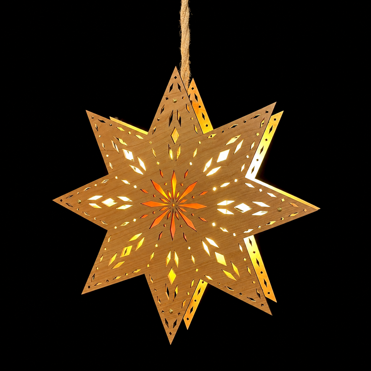 Handcrafted geometric wooden star light hanging by a natural cord against a black background, with warm light shining through its intricate cutouts.
